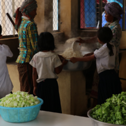 Students and cooks prepare school meal in Cambodia